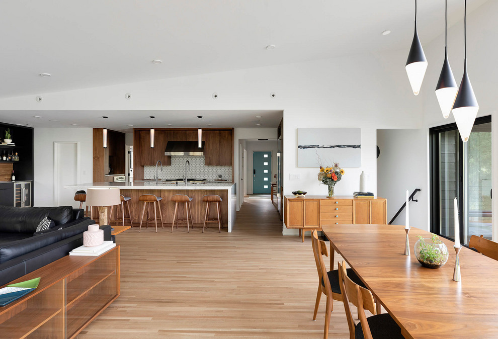 Cette photo montre une salle à manger ouverte sur la cuisine tendance avec un sol marron.