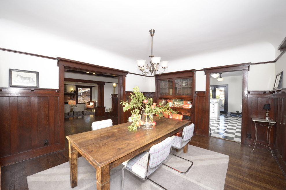Example of a large arts and crafts dark wood floor enclosed dining room design in Los Angeles with white walls and no fireplace