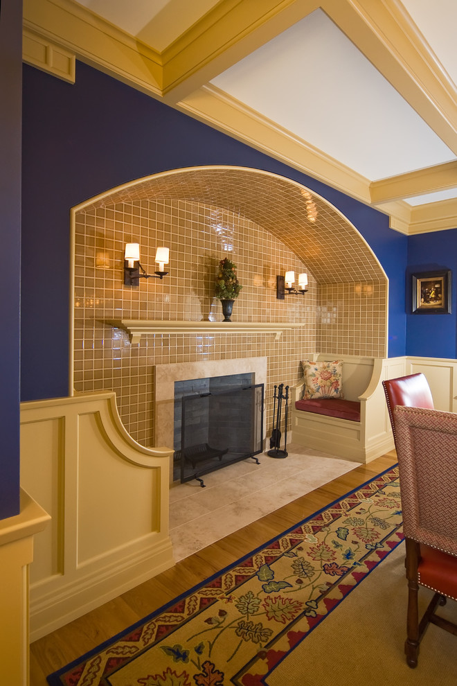 Ispirazione per un'ampia sala da pranzo tradizionale chiusa con pareti blu, pavimento in legno massello medio, camino classico e cornice del camino in pietra