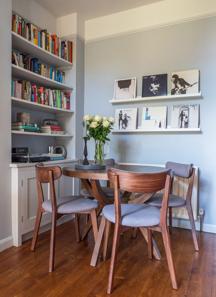 Small contemporary open plan dining room in London with blue walls, medium hardwood flooring and brown floors.