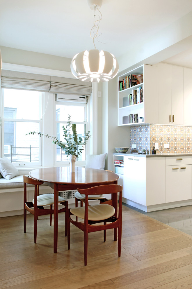 Idée de décoration pour une salle à manger minimaliste avec un mur blanc et parquet clair.