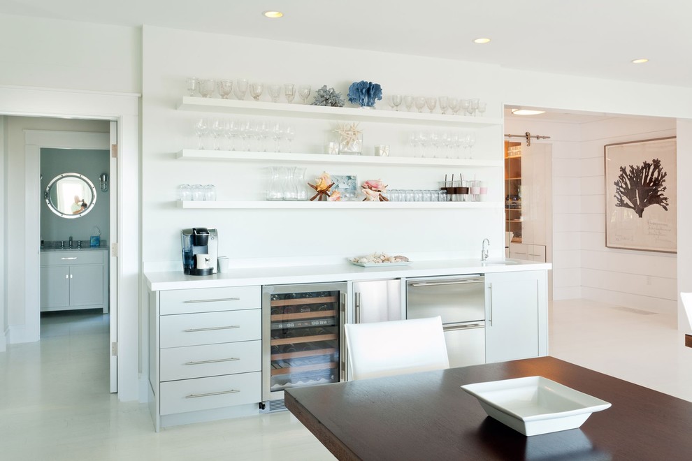Cette image montre une grande salle à manger ouverte sur la cuisine marine avec un mur blanc, parquet clair, un sol blanc et aucune cheminée.