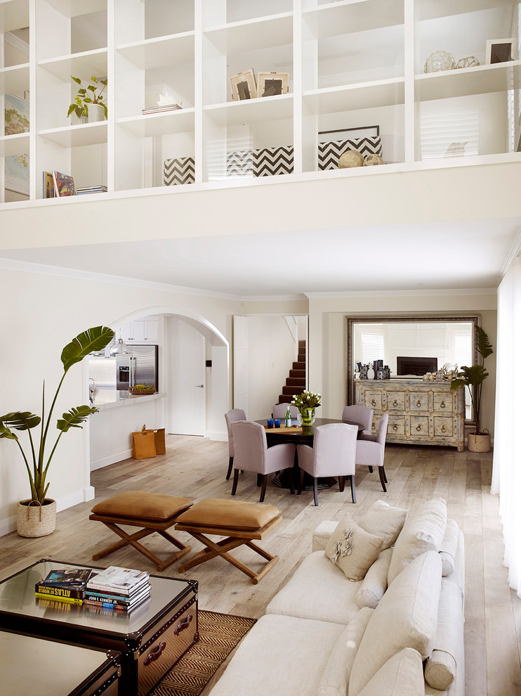 Esempio di una sala da pranzo aperta verso il soggiorno stile marinaro di medie dimensioni con pareti bianche, parquet chiaro e pavimento beige