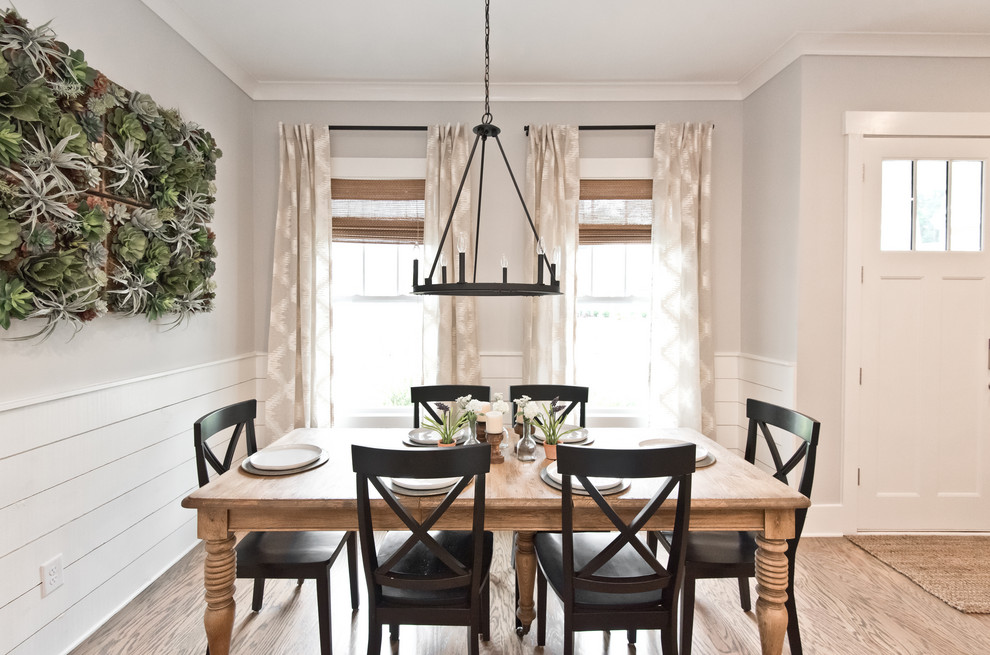 This is an example of a country dining room in Atlanta with grey walls, medium hardwood flooring and brown floors.