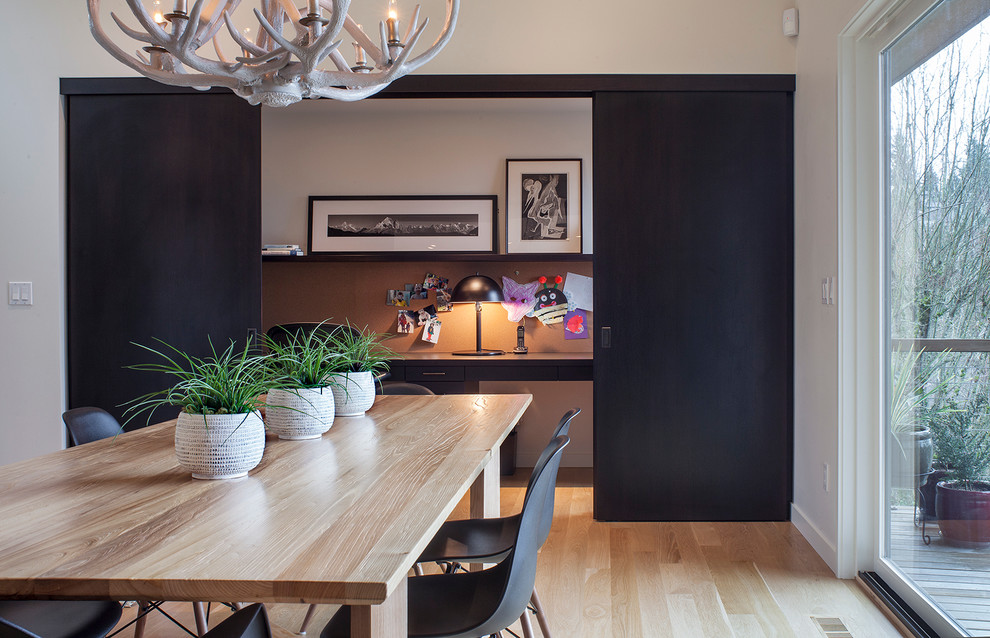 Contemporary dining room in Portland with white walls and medium hardwood flooring.