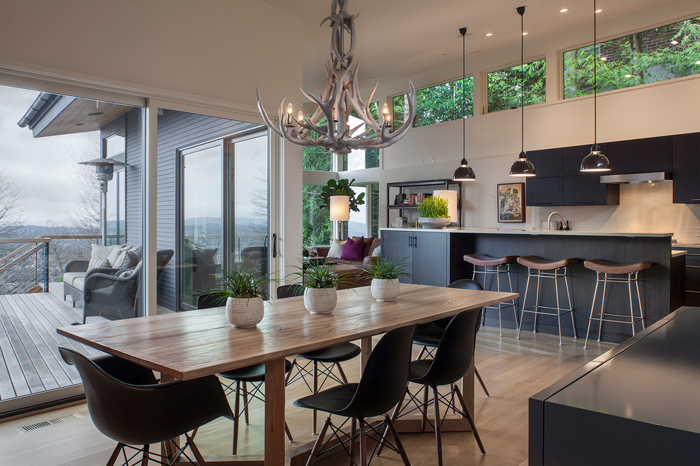 Exemple d'une salle à manger ouverte sur la cuisine tendance avec un sol en bois brun et éclairage.