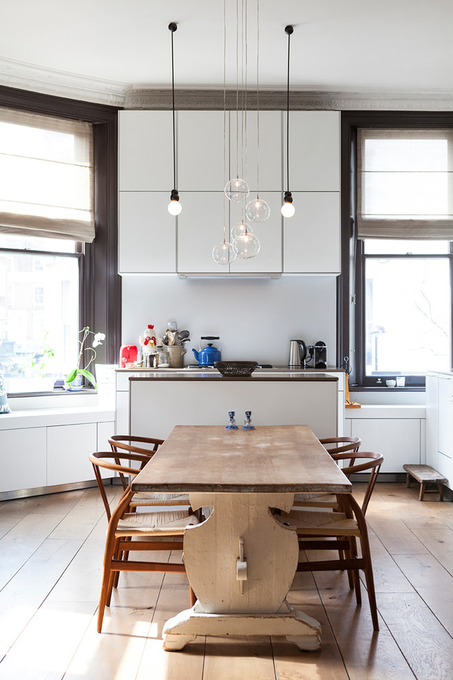 Esempio di una sala da pranzo aperta verso la cucina design con parquet chiaro