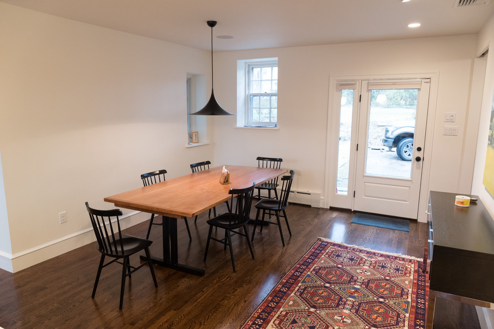 Foto di una sala da pranzo aperta verso il soggiorno chic di medie dimensioni con pareti bianche, parquet scuro, nessun camino e pavimento marrone