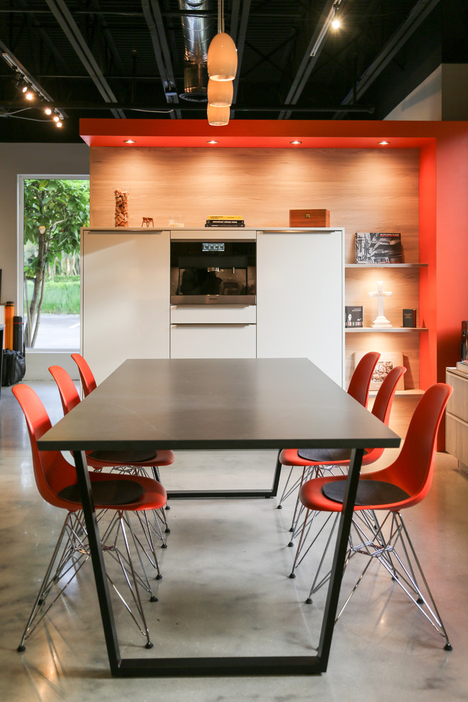 Идея дизайна: большая кухня-столовая в стиле модернизм с оранжевыми стенами, бетонным полом и серым полом