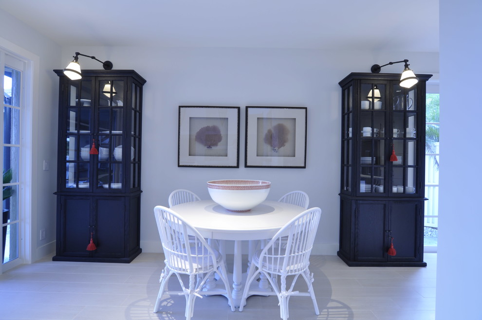 Immagine di una sala da pranzo aperta verso la cucina stile marino di medie dimensioni con pareti bianche, parquet chiaro e nessun camino