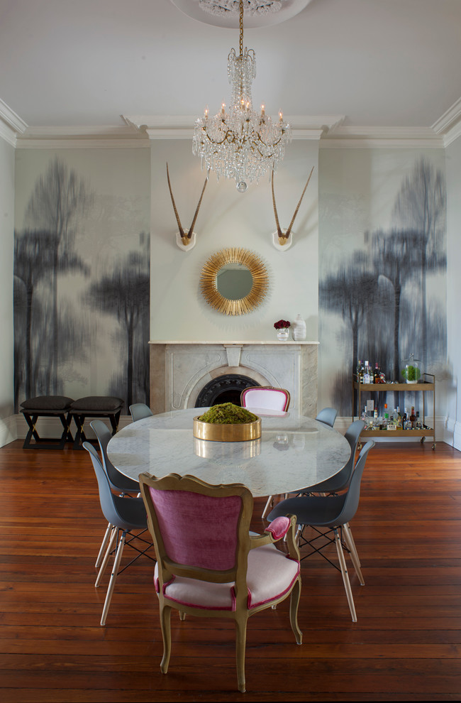 Idée de décoration pour une salle à manger ouverte sur le salon tradition de taille moyenne avec un mur gris, un sol en bois brun, une cheminée standard, un manteau de cheminée en pierre et un sol marron.