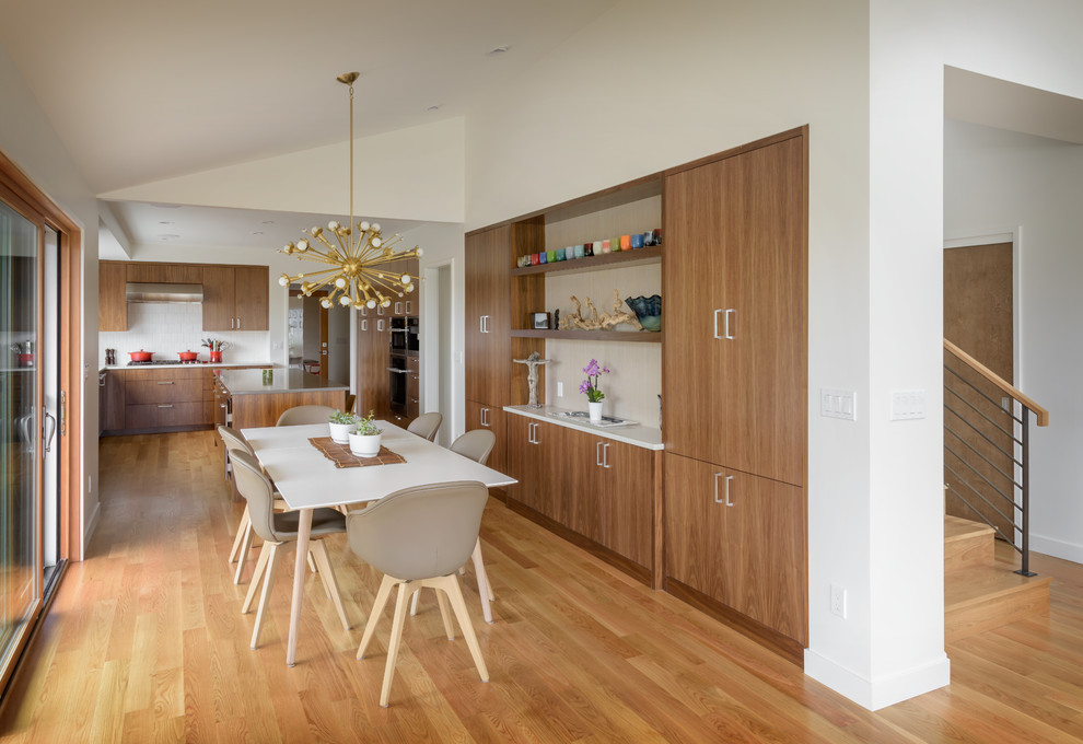 Esempio di una sala da pranzo aperta verso il soggiorno minimalista con pareti bianche, pavimento in legno massello medio e pavimento marrone