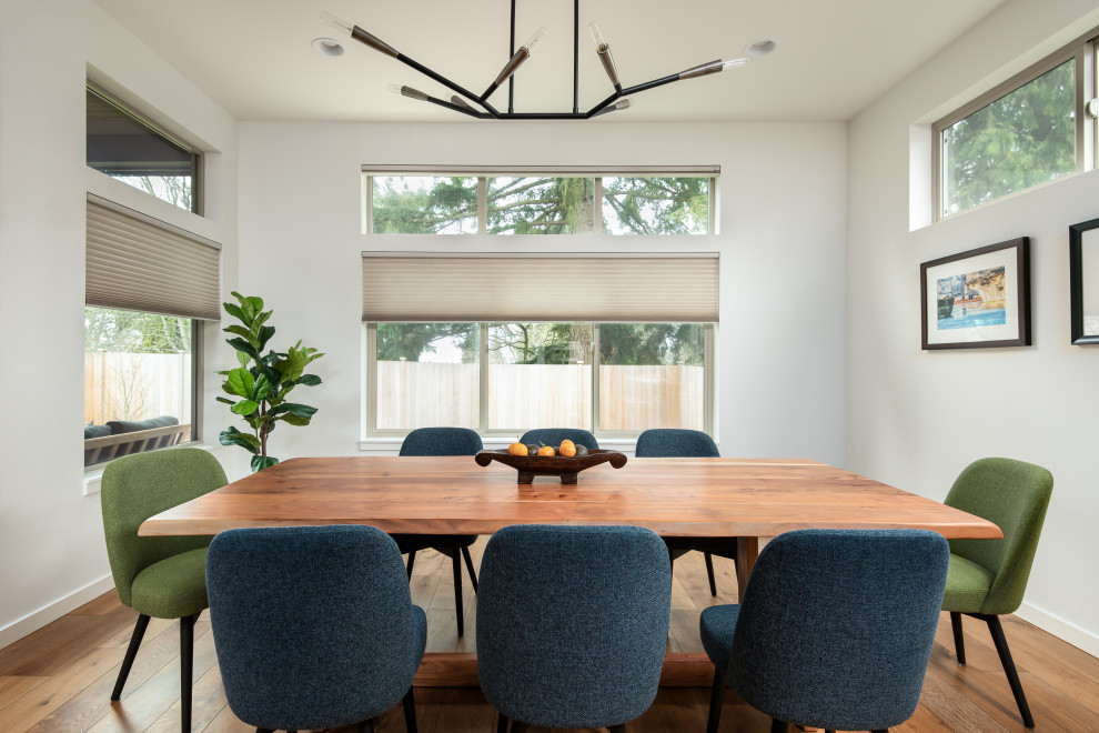 Esempio di una sala da pranzo aperta verso la cucina minimal di medie dimensioni con pareti bianche, pavimento in legno massello medio e pavimento marrone