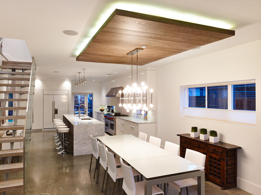 Moderne Wohnküche ohne Kamin mit weißer Wandfarbe und Betonboden in Vancouver