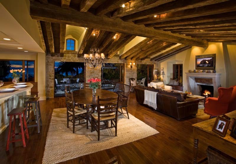 Aménagement d'une salle à manger ouverte sur le salon campagne de taille moyenne avec un mur beige, un sol en bois brun, une cheminée standard et un manteau de cheminée en bois.