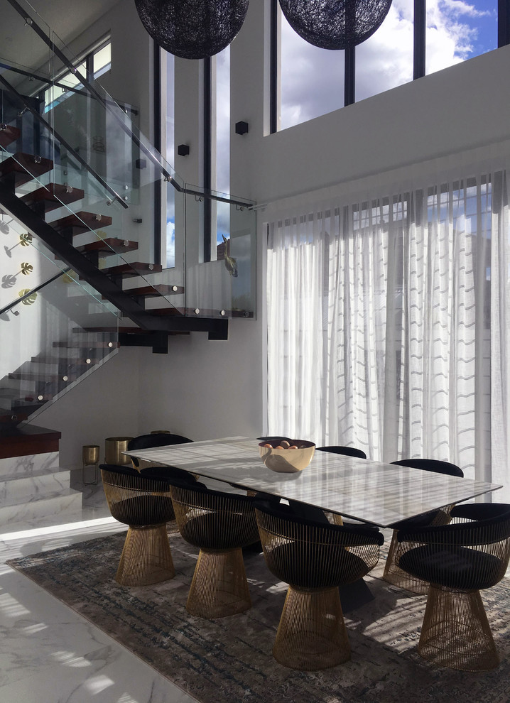 Foto di una sala da pranzo aperta verso la cucina contemporanea di medie dimensioni con pareti bianche, pavimento bianco e pavimento in marmo