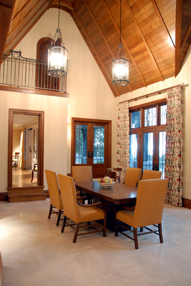 На фото: большая отдельная столовая в классическом стиле с бежевыми стенами, полом из известняка и фасадом камина из дерева