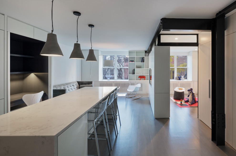 Idée de décoration pour une petite salle à manger ouverte sur la cuisine minimaliste avec un mur blanc, parquet clair et un sol gris.