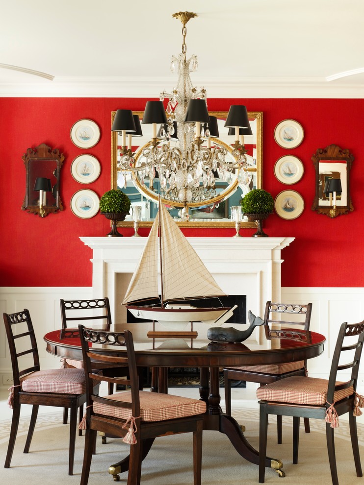 Exemple d'une salle à manger bord de mer avec un mur rouge et une cheminée standard.