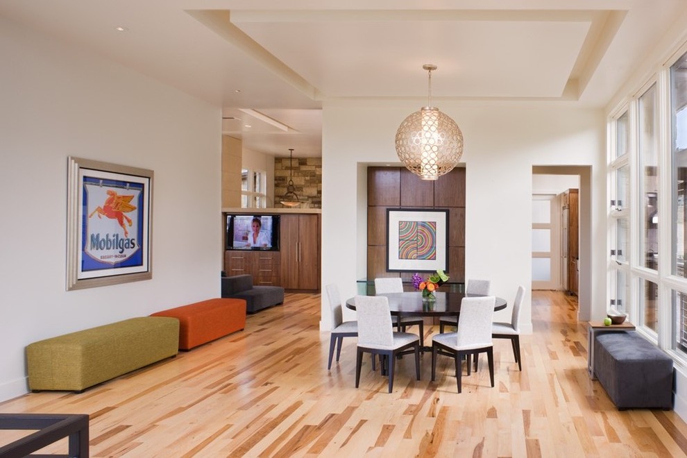 Geschlossenes Modernes Esszimmer mit weißer Wandfarbe und braunem Holzboden in Austin