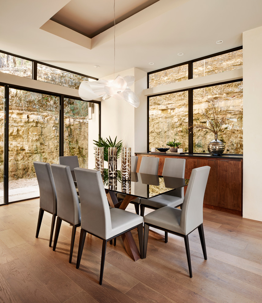 Medium sized contemporary dining room in Austin with white walls and medium hardwood flooring.
