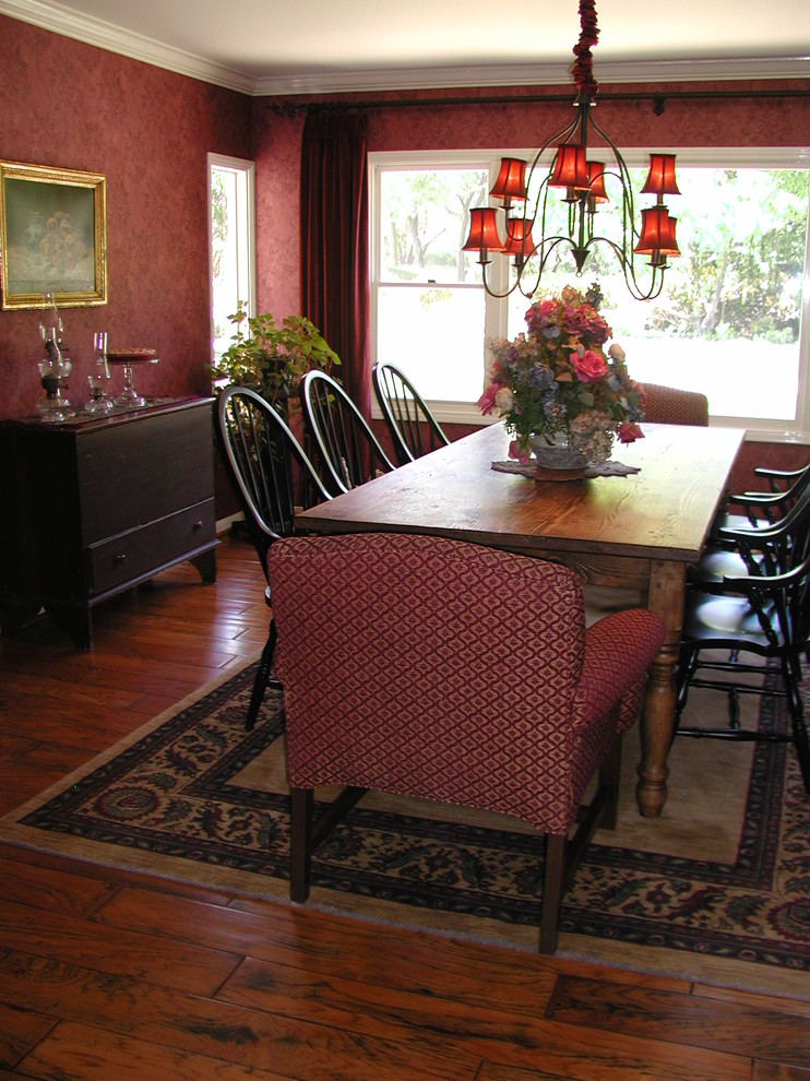 Esempio di una sala da pranzo classica chiusa e di medie dimensioni con pareti rosse, pavimento in legno massello medio e nessun camino