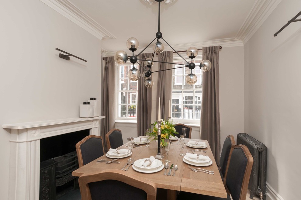 Mittelgroße Moderne Wohnküche mit grauer Wandfarbe, hellem Holzboden, Kaminumrandung aus Stein und Kamin in London