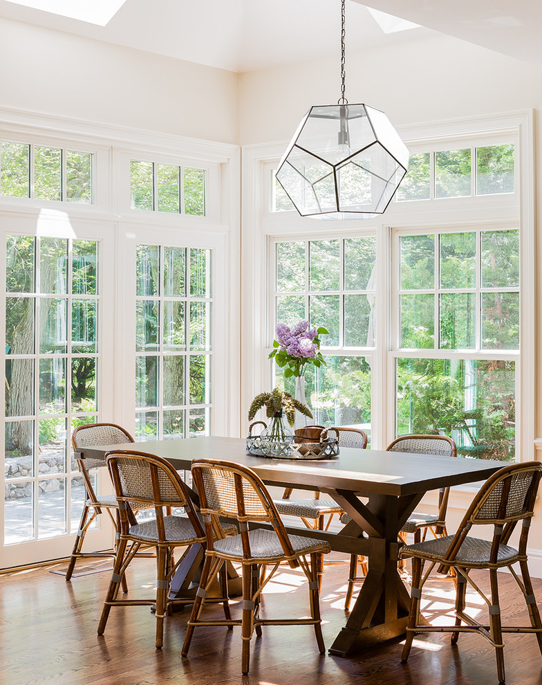 This is an example of a classic dining room in Boston with white walls and medium hardwood flooring.