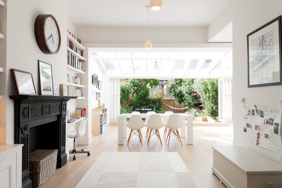 Offenes Modernes Esszimmer mit weißer Wandfarbe, hellem Holzboden, Kamin und braunem Boden in London