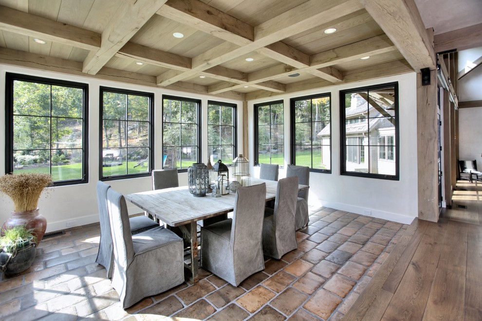 Example of a mid-sized mountain style brick floor kitchen/dining room combo design in Other with white walls
