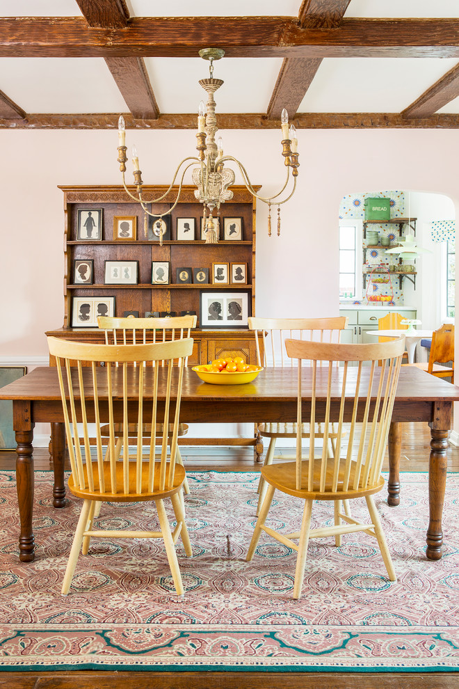 Example of a mid-sized country dark wood floor, brown floor, wainscoting and exposed beam enclosed dining room design in Los Angeles with pink walls