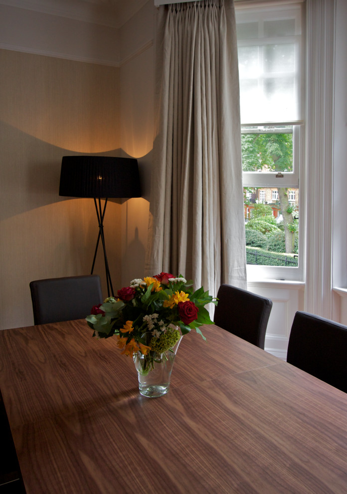 Medium sized contemporary enclosed dining room in London with beige walls and medium hardwood flooring.