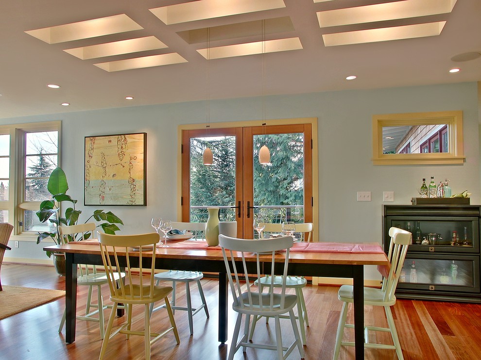 Réalisation d'une salle à manger design avec un mur bleu et un sol en bois brun.