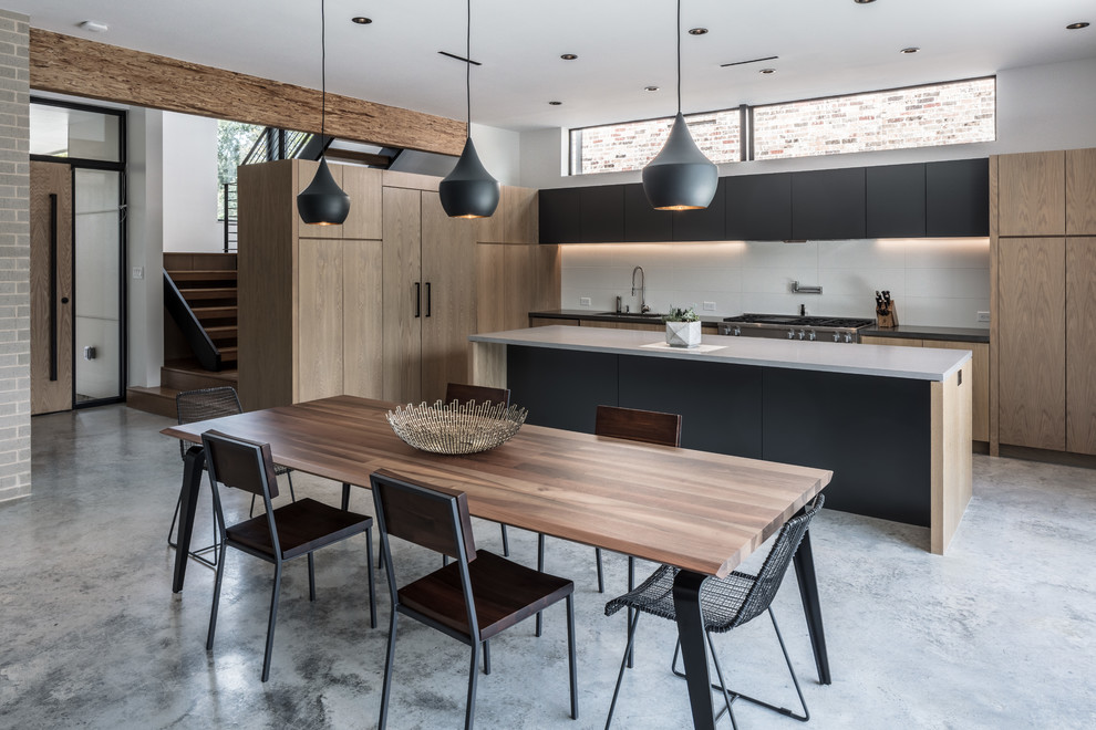 Ispirazione per una sala da pranzo aperta verso la cucina design di medie dimensioni con pavimento in cemento, pavimento grigio e pareti bianche