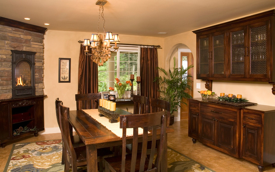 Cette image montre une salle à manger traditionnelle fermée et de taille moyenne avec un mur beige, un sol en liège, une cheminée d'angle et un manteau de cheminée en pierre.