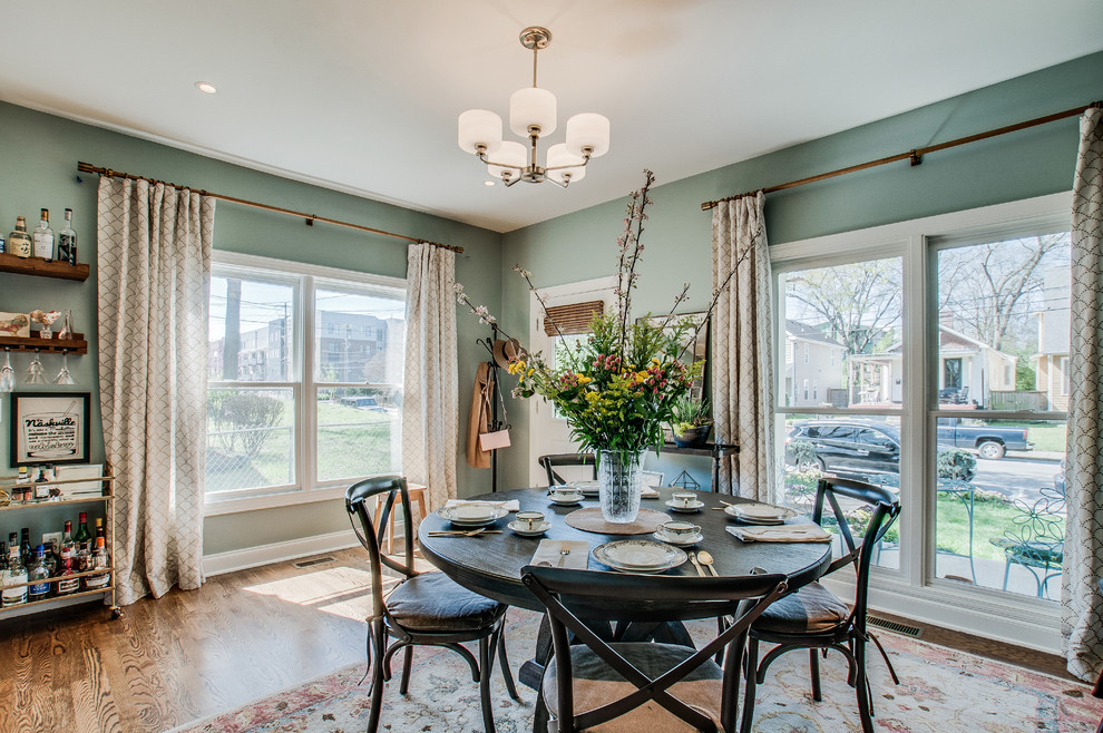 Medium sized traditional open plan dining room in Nashville with green walls, light hardwood flooring, no fireplace and brown floors.