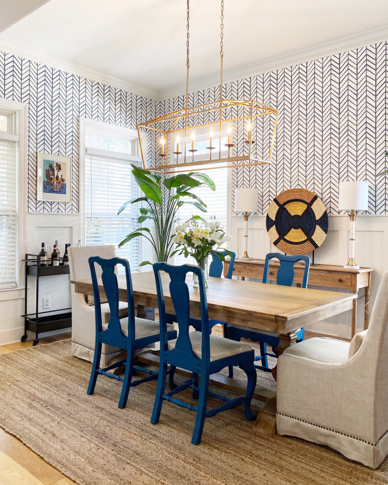 Imagen de comedor costero grande con paredes blancas, suelo de madera clara y suelo beige