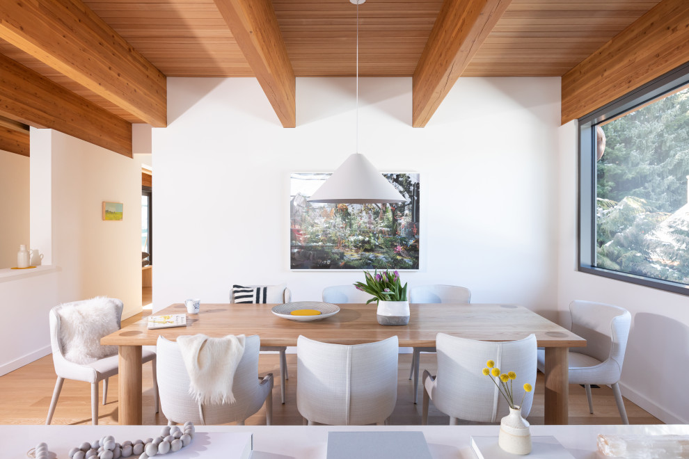 Modernes Esszimmer ohne Kamin mit hellem Holzboden, braunem Boden, freigelegten Dachbalken und Holzdecke in Vancouver