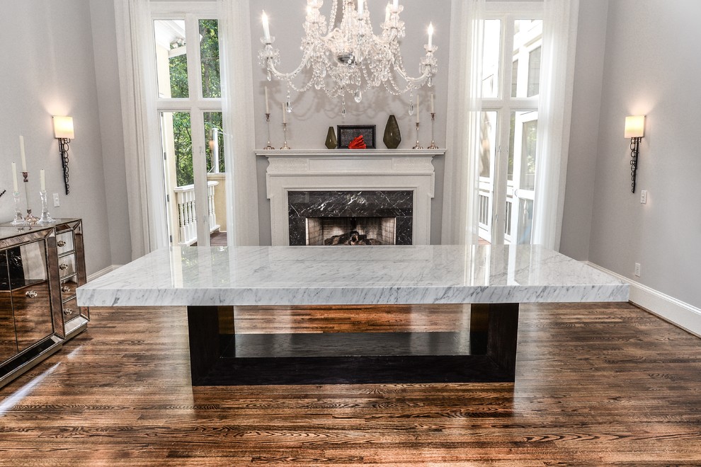 Photo of a shabby-chic style kitchen/dining room in Atlanta with grey walls, a standard fireplace, a stone fireplace surround and brown floors.