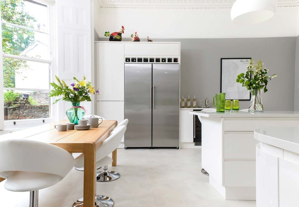 Idée de décoration pour une salle à manger ouverte sur la cuisine design de taille moyenne avec un mur gris, sol en béton ciré et un sol gris.
