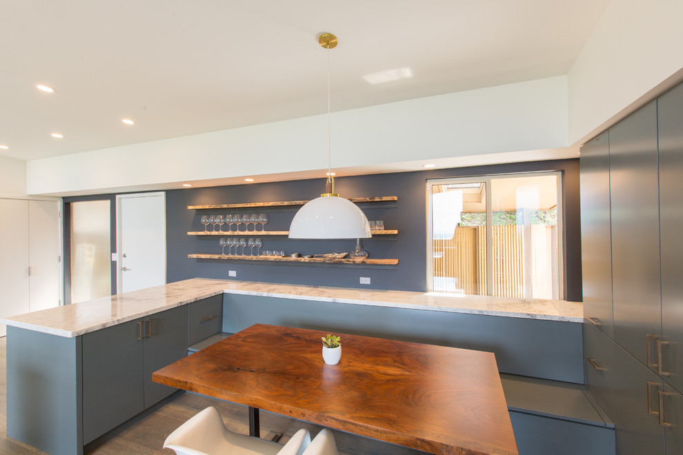 Ispirazione per una sala da pranzo aperta verso la cucina minimalista di medie dimensioni con pareti blu e parquet chiaro