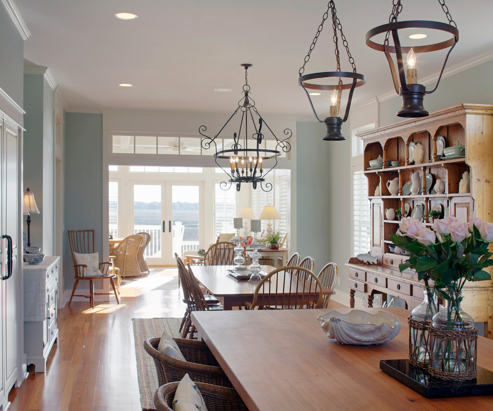 Esempio di una grande sala da pranzo aperta verso la cucina stile marino con pareti blu, pavimento in legno massello medio e nessun camino