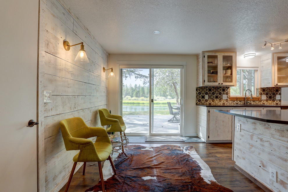 Foto di una sala da pranzo aperta verso il soggiorno rustica di medie dimensioni con pareti bianche, pavimento in laminato e pavimento marrone