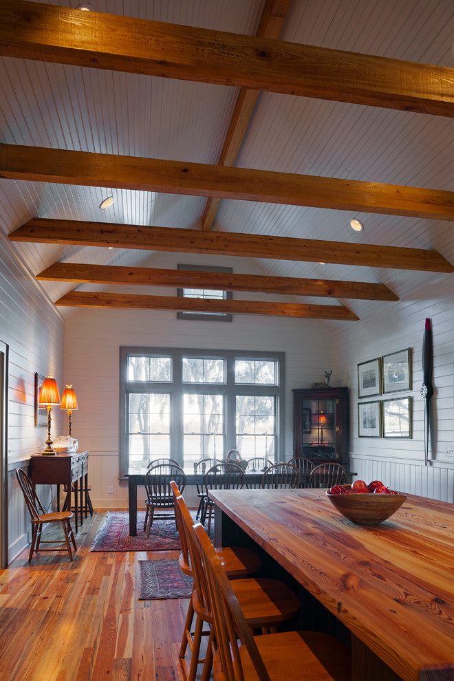 Foto di una grande sala da pranzo aperta verso la cucina country con pareti bianche e parquet chiaro