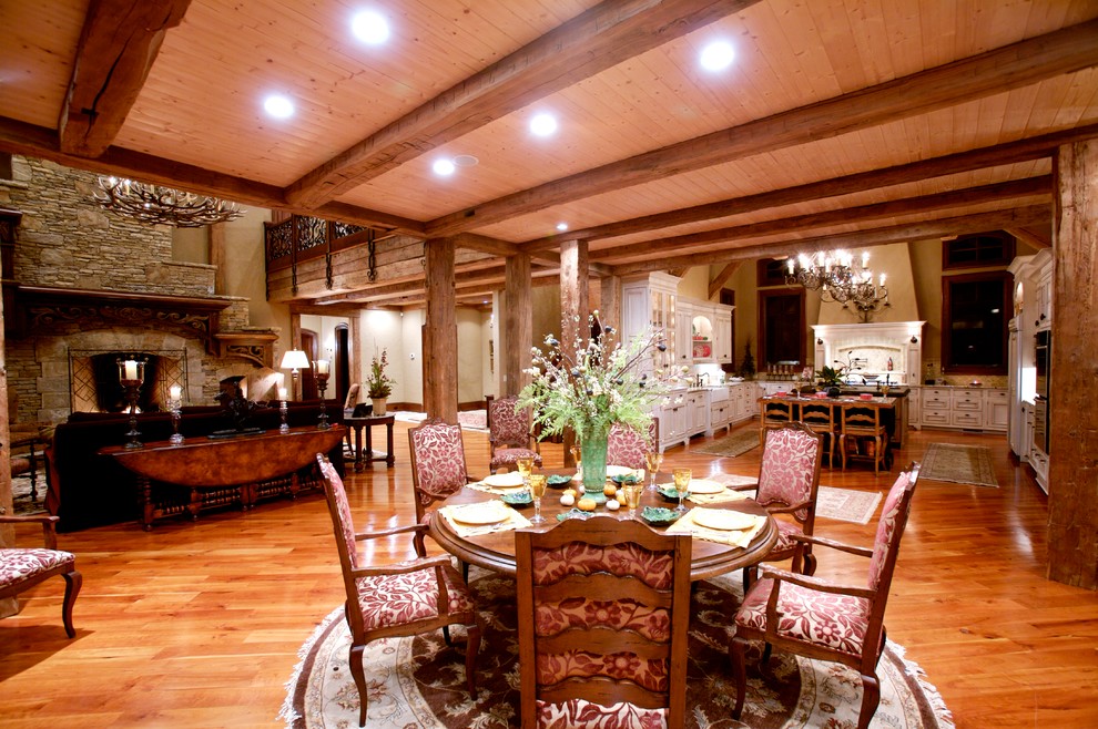 Exemple d'une très grande salle à manger ouverte sur le salon montagne avec un mur beige et un sol en bois brun.