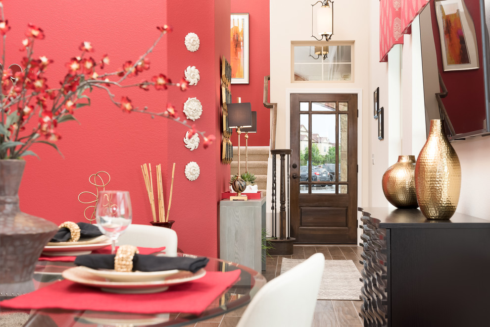 Imagen de comedor actual de tamaño medio sin chimenea con paredes rojas y suelo de baldosas de porcelana