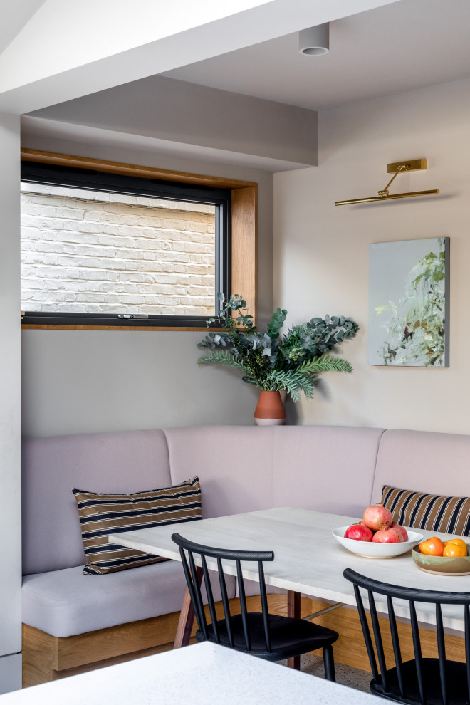 Idées déco pour une salle à manger contemporaine avec une banquette d'angle, un mur beige et un sol gris.