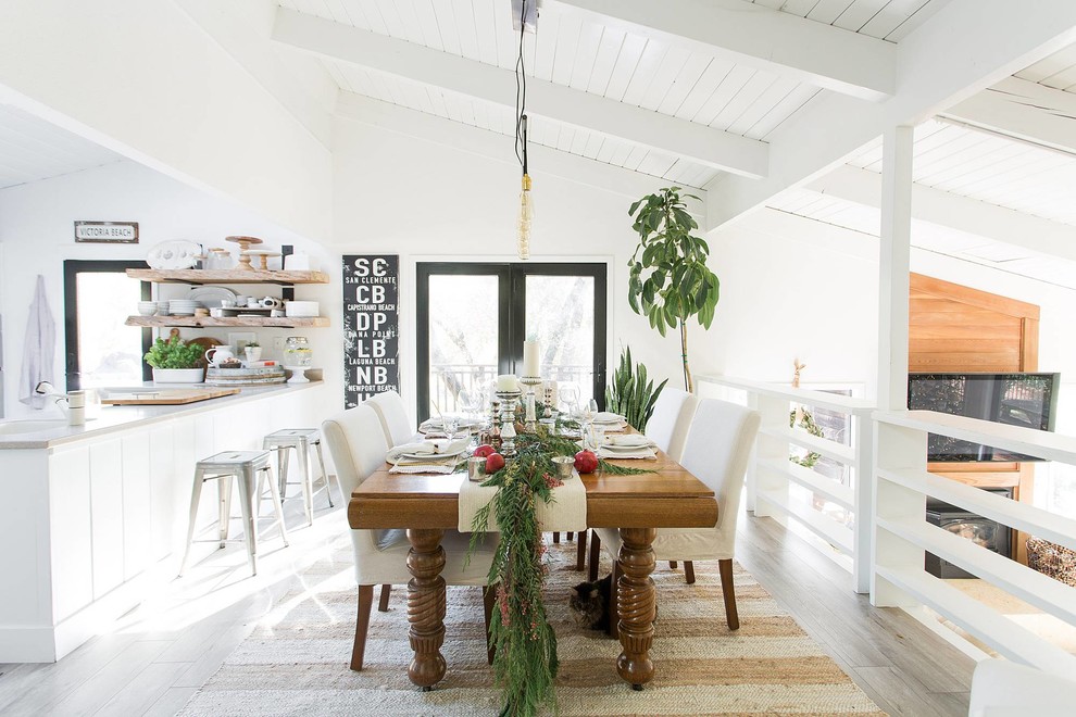 Idée de décoration pour une salle à manger ouverte sur la cuisine champêtre avec un mur blanc et un sol beige.