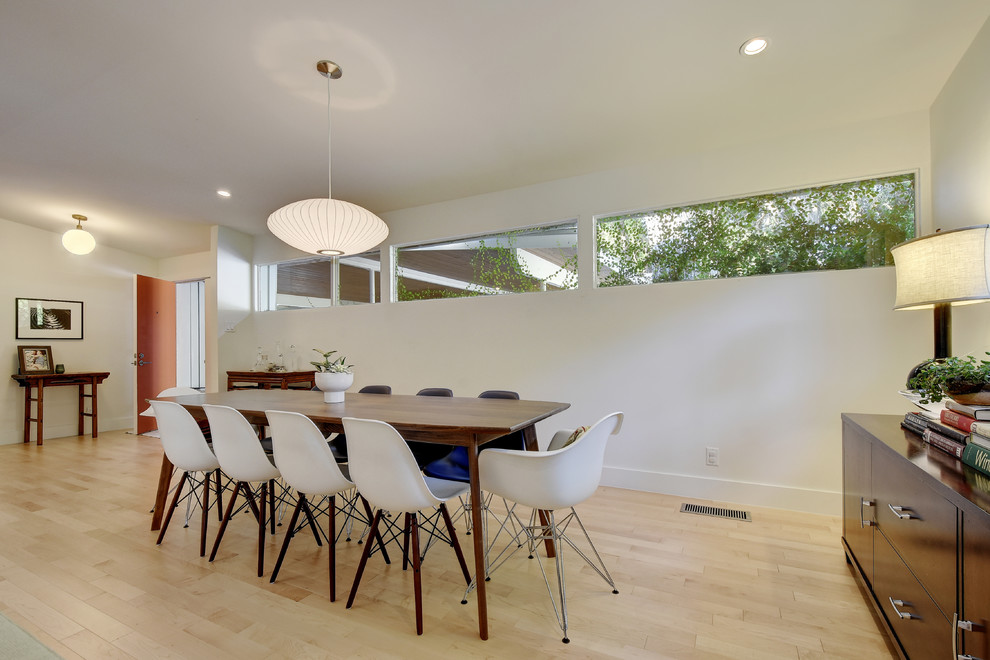 Ispirazione per una grande sala da pranzo aperta verso la cucina minimalista con pareti bianche e parquet chiaro