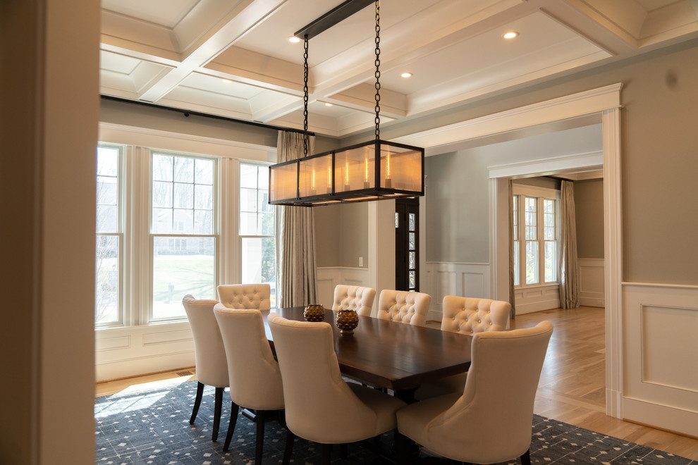 Example of a large classic light wood floor and brown floor enclosed dining room design in DC Metro with beige walls and no fireplace